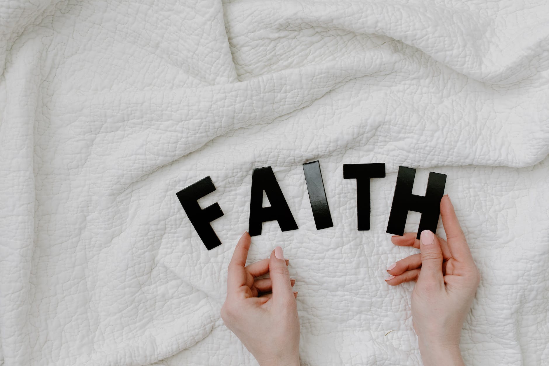 a person holding cutout letters on the white textile